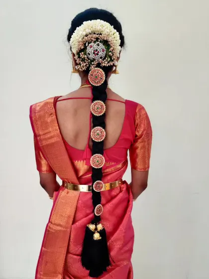 For Poornima's engagement, we created this stunning traditional braid using circular, stone-studded ornaments and fresh flowers. This style is perfect for adding a touch of grandeur to any ethnic outfit.