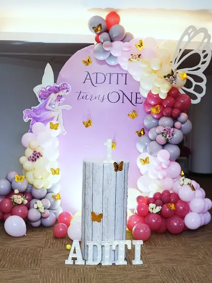 A simple and elegant fairy butterfly theme for Aditi's first birthday. We used a soft pink backdrop with a delicate balloon garland in shades of pink, white, and maroon, accented with butterflies.