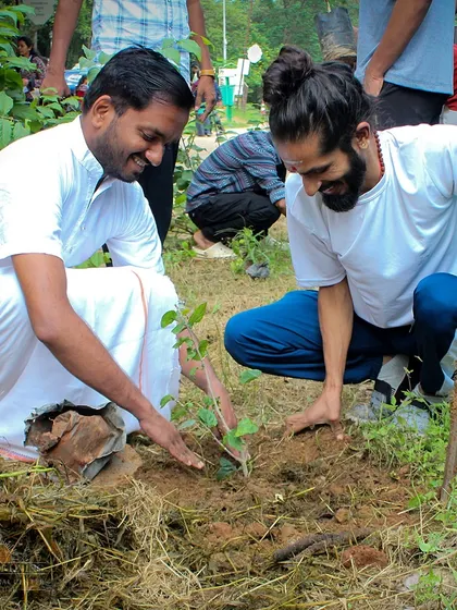 Two volunteers work together to plant a tree. Seva provides a wonderful opportunity to connect with like-minded people while contributing to a common goal.