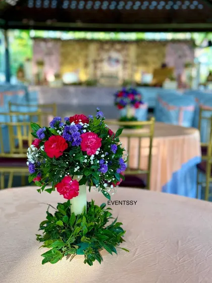 A floral centerpiece for one of the guest tables at the naming ceremony. Using consistent floral arrangements throughout the venue ensures a cohesive and elegant look for the entire event.