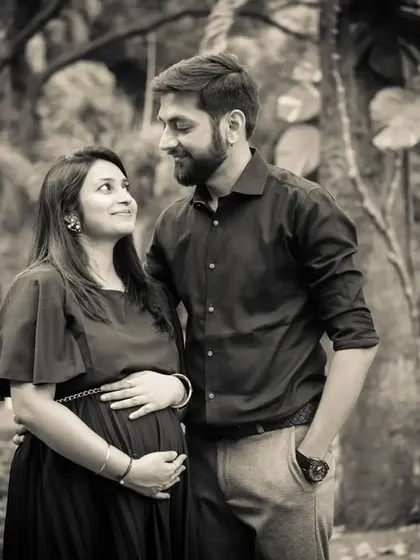 A timeless black and white portrait. The natural park setting and the couple's gentle interaction create a photo that is both classic and full of genuine emotion.