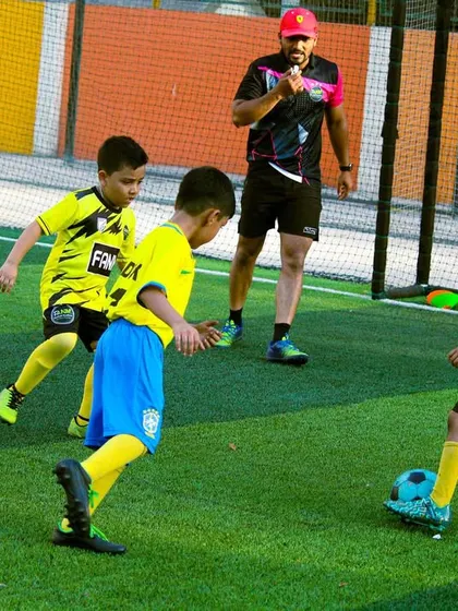 A coach oversees a drill, ensuring players are executing it correctly and safely.