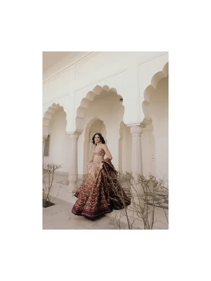A full length portrait of Sandy, framed by the beautiful arches of the Sukhvilas, showcasing her grace and the elegance of her attire.