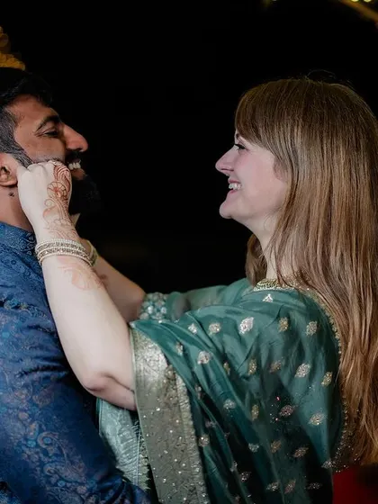 A playful, candid moment between a cross-cultural couple during their reception.