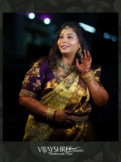 The intricate details of the yellow and purple brocade saree shine in this candid shot.