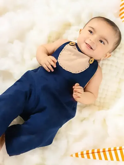 A baby boy lies back on a fluffy cloud, looking relaxed and dreamy.
