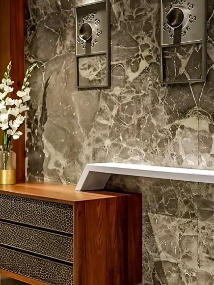 A close-up of a custom storage cabinet with textured drawer fronts, set against a dramatic dark marble wall. This shows our focus on unique materials and finishes.