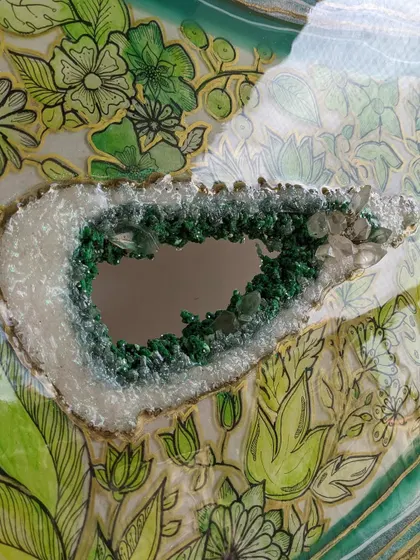 Another perspective on my green geode art. Here you can see the mirror-like center, surrounded by textured green crystals and delicate, hand-drawn leaves, all encased in glossy resin.