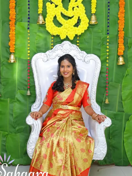 A classic and traditional baby shower setup. The backdrop of fresh banana leaves, marigold garlands, and brass bells creates an auspicious and beautiful setting for the mother-to-be.