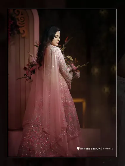 A stunning solo portrait of the bride-to-be in her elegant pink gown, showcasing her grace and style.