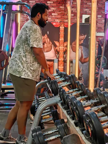 A client selects dumbbells from the rack for his workout. Our gym is fully equipped with a wide range of weights for every type of training, from light conditioning to heavy lifting.