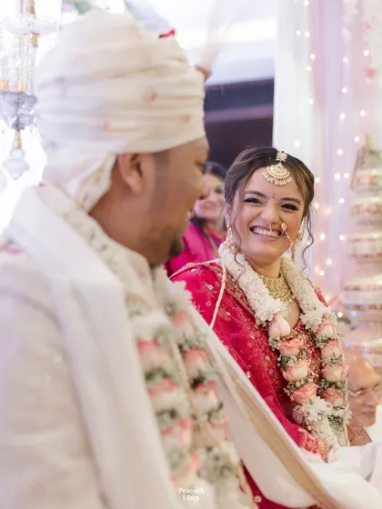 A beautiful candid shot of the bride looking at her groom with a radiant smile during their wedding ceremony.