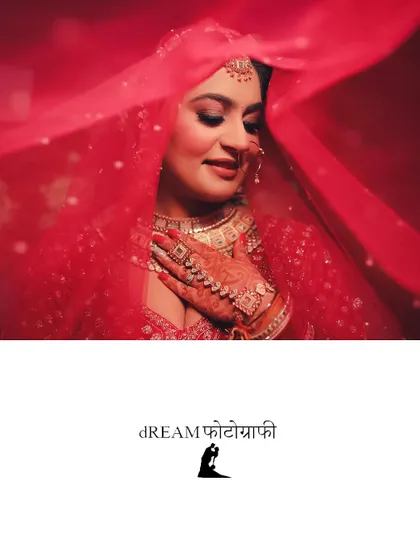A beautiful portrait of bride Nikita, her face veiled in red, capturing a moment of serene anticipation.
