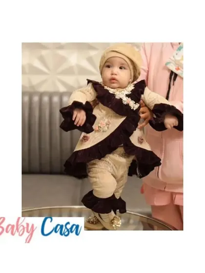 This little girl looks absolutely stunning in her first Lohri outfit. The unique, high fashion design with ruffled velvet details makes her the star of the celebration.