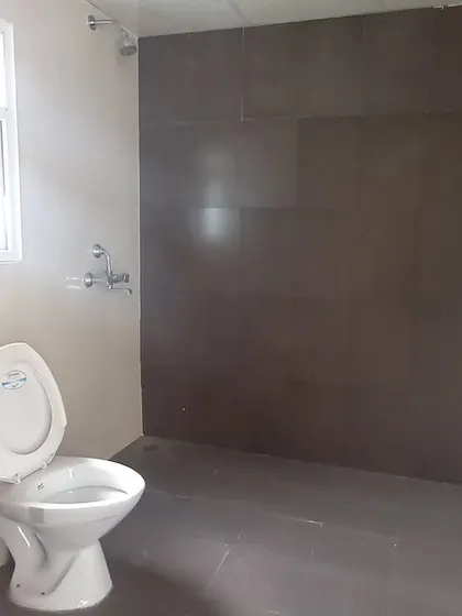 **BEFORE:** A basic bathroom with dated, dark brown tiles and standard fixtures, lacking both function and style.