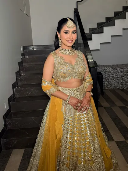 Garima looking absolutely stunning. The smokey eyes and pink lips are a timeless choice that perfectly complements her yellow and gold lehenga.