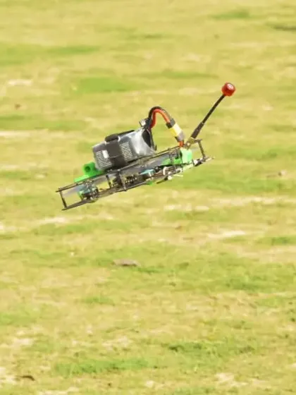 A custom-built FPV drone captured mid-flight over a green field. This demonstrates the agility and stability you can achieve with a well-built and properly tuned quadcopter.