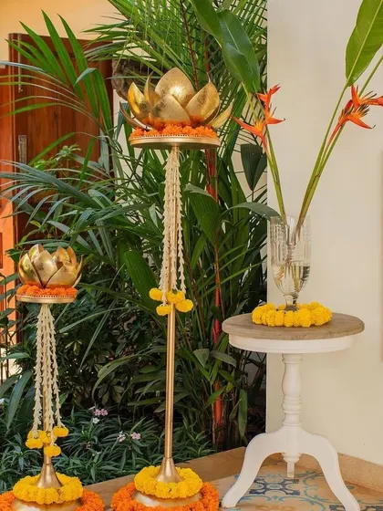 Traditional brass lotus lamps decorated with marigold garlands, adding an authentic touch to the decor.
