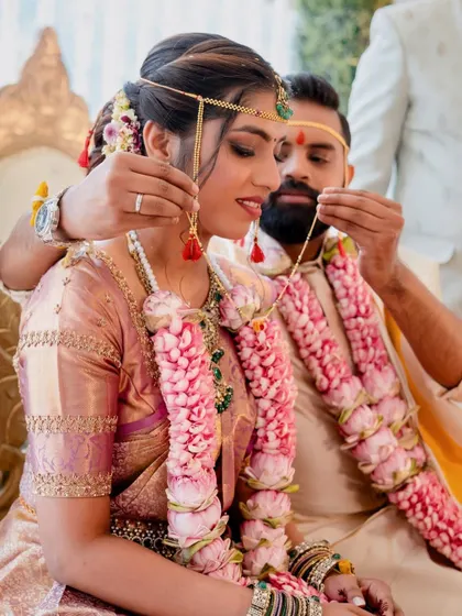 The significant moment of the Thaali ceremony in a South Indian wedding. The bride's jewelry and the thick, fragrant lotus garlands we provided add to the richness of the scene.
