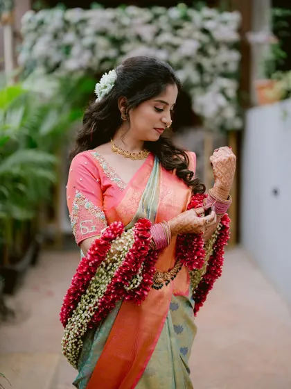 A beautiful portrait of the bride, Gayatri, adjusting her traditional floral arm ornaments.