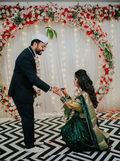 A unique engagement moment where the bride-to-be kneels to put a ring on her partner.