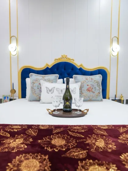 Inspired by Regency-era elegance, this master bedroom features a bold, royal blue tufted headboard set against a classic white and gold backdrop. It’s a testament to how we can infuse personality and a touch of royal glamour into any space.
