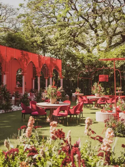 A wide view of the 'Gulal Bagh' setup, showing how the bold red structures and furniture create a cohesive and powerful design statement.
