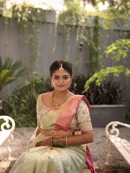 The bride seated, looking elegant and poised. The makeup is designed to look flawless in professional photos, ensuring every moment is captured beautifully.