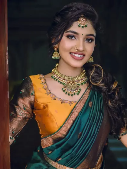 A close-up shot of the mustard and green half-saree, focusing on the beautiful necklace and makeup that complete the look.