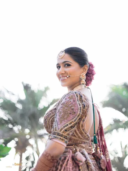 A lovely over-the-shoulder smile from the bride, her makeup looking fresh and radiant.
