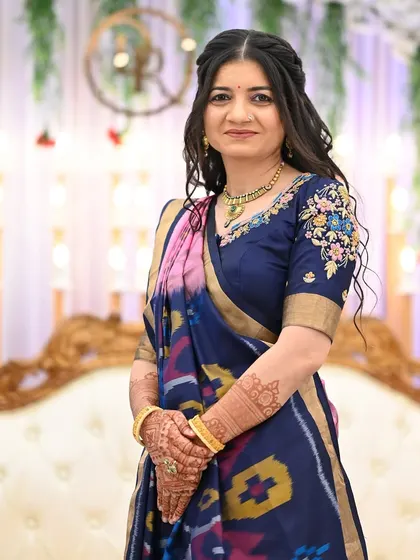 An elegant guest at a wedding, her simple yet beautifully stained mehendi peeking through.