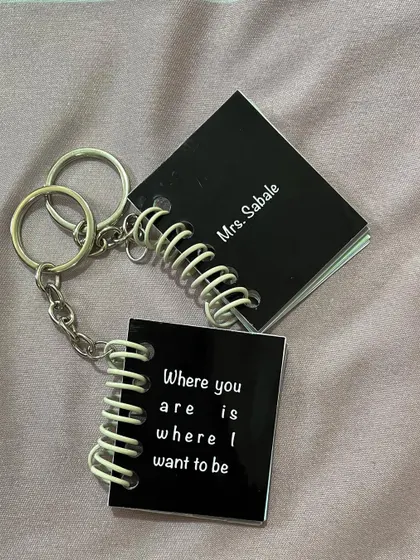 Two mini booklet keychains, showing different custom messages on the cover.