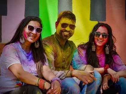 Friends relaxing and smiling, covered in a rainbow of colors. Beyond the dancing, I help create a space for connection and celebration.