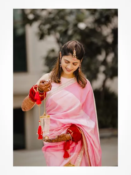 A smiling bride holding her kalire, a beautiful pre-wedding ritual shot.