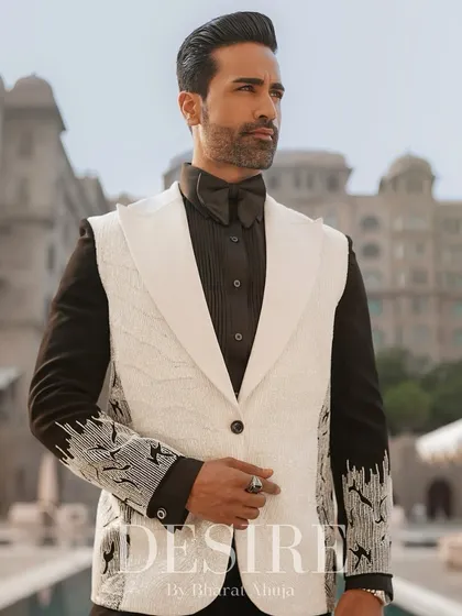 This image captures the sophistication of the sleeveless white blazer. The combination of the textured white vest, black shirt, and bow tie is pure elegance.