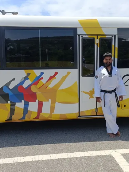 Posing next to a Taekwondowon shuttle bus, decorated with the art we all love.