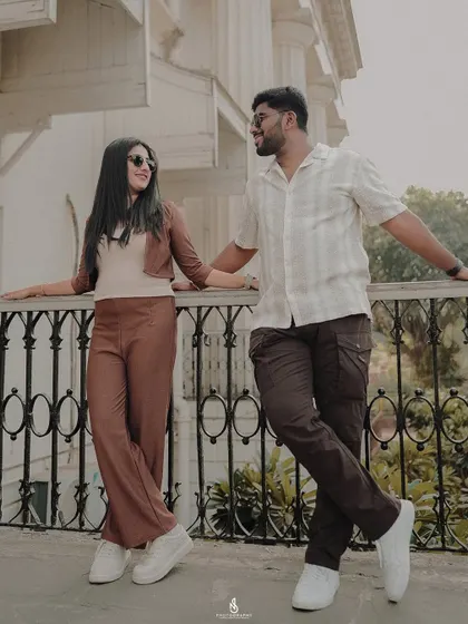 A relaxed moment, leaning against a balcony railing. This pose is perfect for capturing a candid, conversational feel.