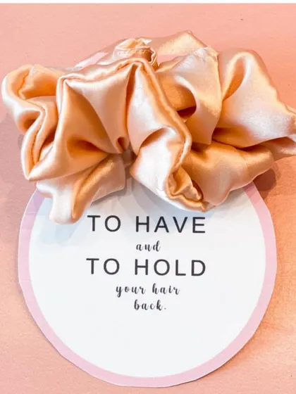 "To have and to hold your hair back." A cute, custom-tagged satin scrunchie, a small but thoughtful addition to any bridal or bridesmaid gift.