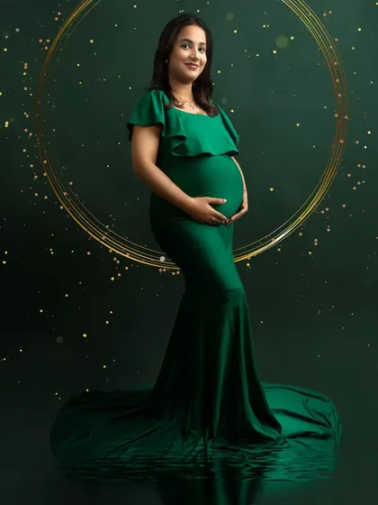 An elegant portrait in a dark green gown with a sparkling, digitally created background. The golden ring of light adds a magical touch.