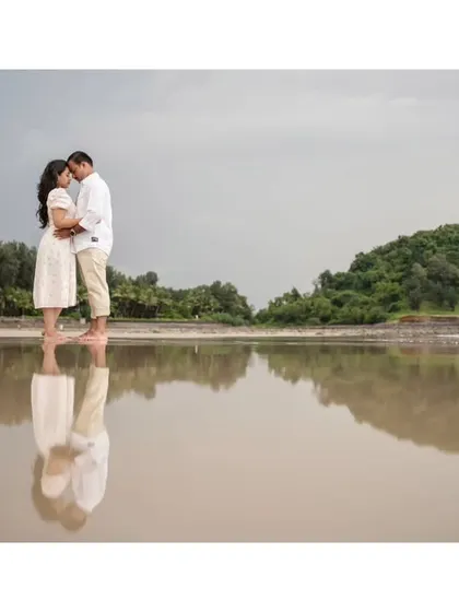 A beautiful reflection shot on a wet beach, creating a mirror image of the couple's love against the vast landscape.