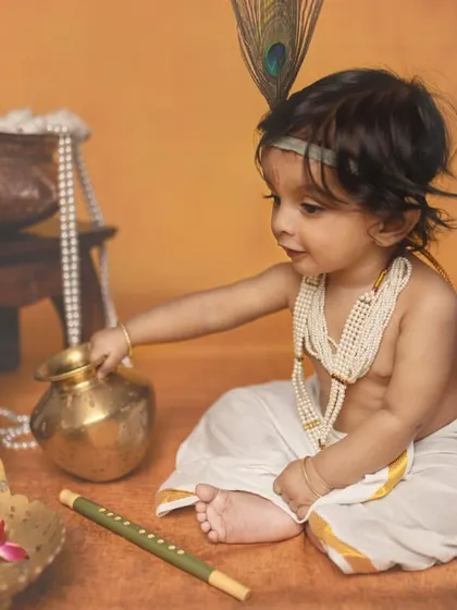 A playful little Krishna reaches for a pot, with his flute resting nearby. I use props to create a narrative within the portrait, telling a small story in a single frame.