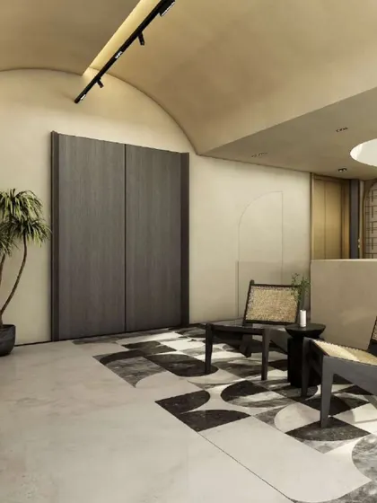 This transition space on a terrace floor uses a muted grey and beige palette, accentuated by a geometric marble inlay floor. The arched ceiling and minimalist rattan chairs create an ambiance of understated luxury.