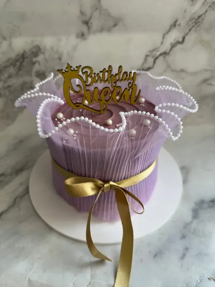 A "Birthday Queen" deserves a royal cake. This design is wrapped in delicate purple tulle and tied with a gold satin ribbon, creating a truly unique and gift-like presentation.