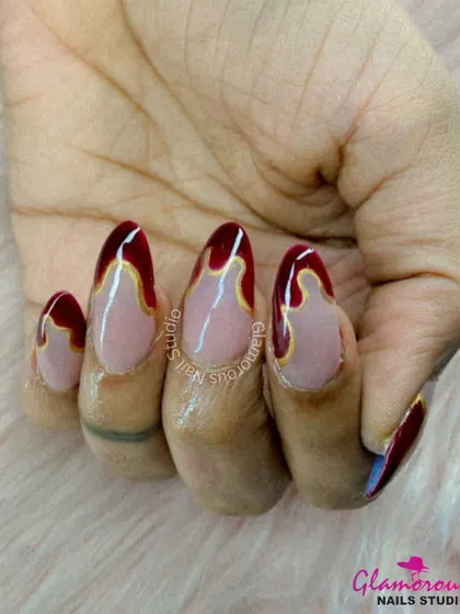 Dripping with glamour. This unique design features a nude base with a deep red "drip" effect from the cuticle, outlined in a fine gold line for a look that is both artistic and luxurious.