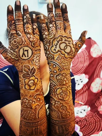 A playful pose from an engagement bride, showing off her beautiful mehndi which includes her initials 'KY' and the words 'Just Engaged'.