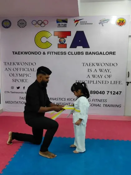 Tying a yellow belt for a young girl.