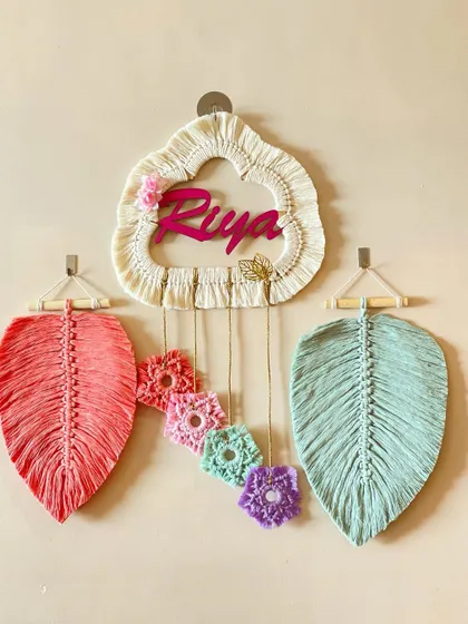 A beautiful, dreamy nameplate created for Riya. The cloud-shaped hoop, pastel flowers, and hanging leaves create a soft and whimsical feel.
