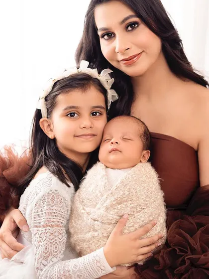 A mother, her older daughter, and the new baby. This portrait beautifully captures the love and bond between three generations of girls.