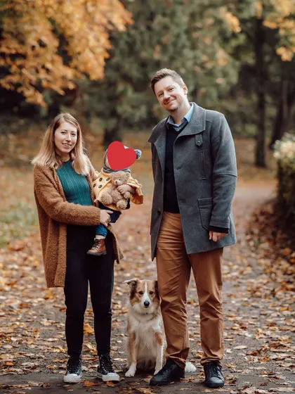 A lovely family of four, including their furry member, enjoying a walk on a path covered in autumn leaves. These sessions are perfect for capturing your family's annual photo.
