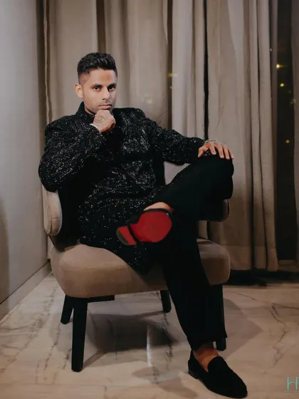A relaxed pose from Suryakumar, showing off his red-soled loafers which add a pop of color to the all-black ensemble.